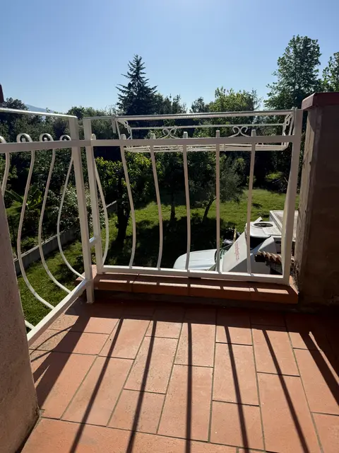 Ringhiera bianca del terrazzo riverniciata con vista sul giardino