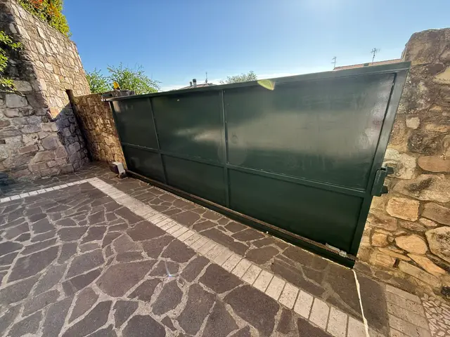 Cancello scorrevole in ferro riverniciato di verde scuro