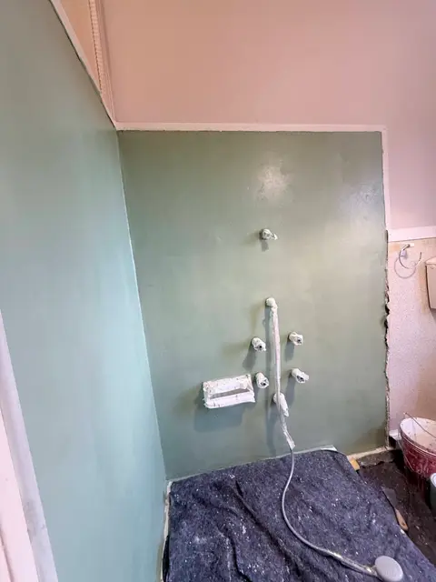 Applicazione della resina verde sulla parete della doccia